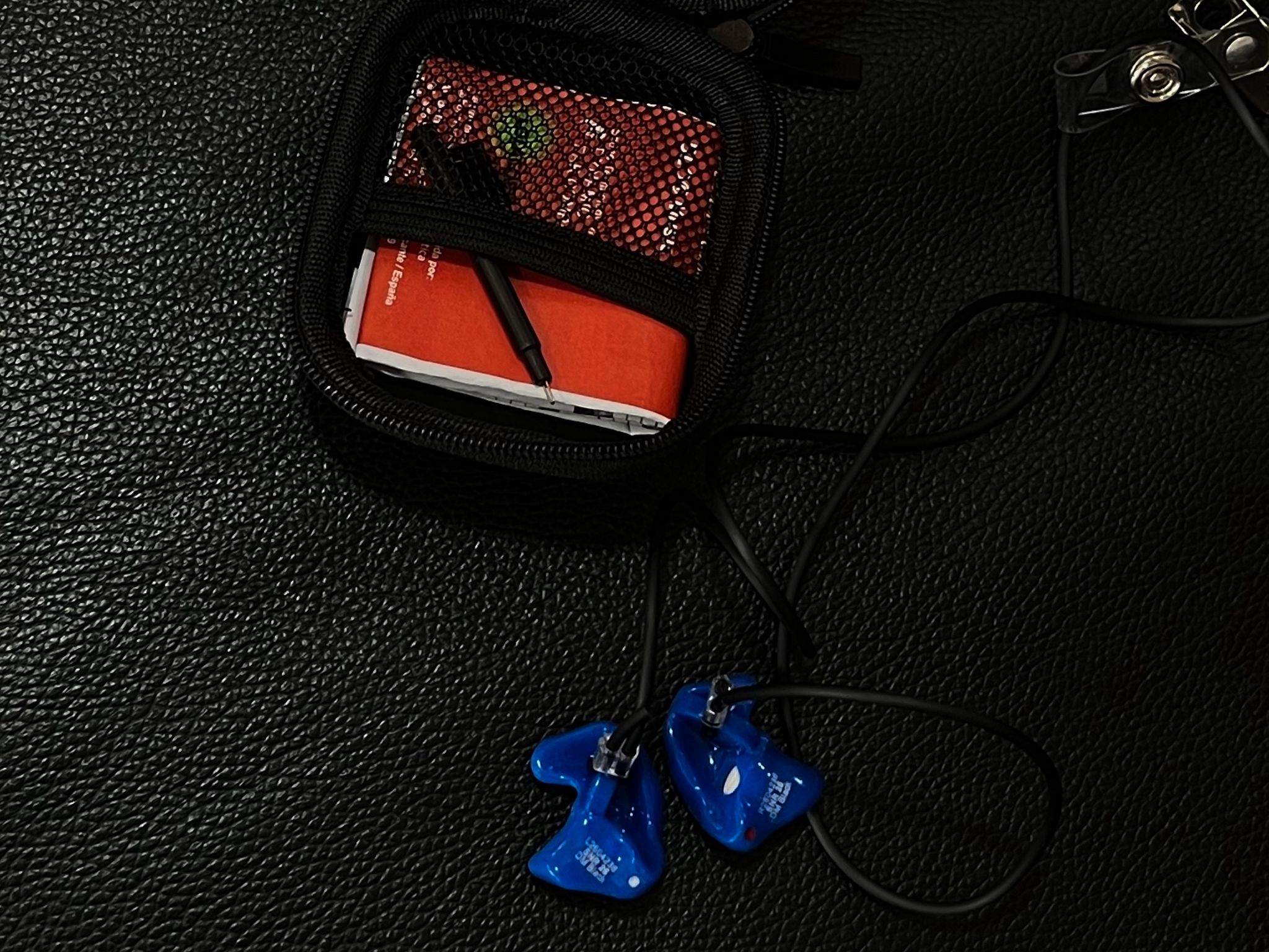 Protectores auditivos azules con cordón sobre una superficie negra